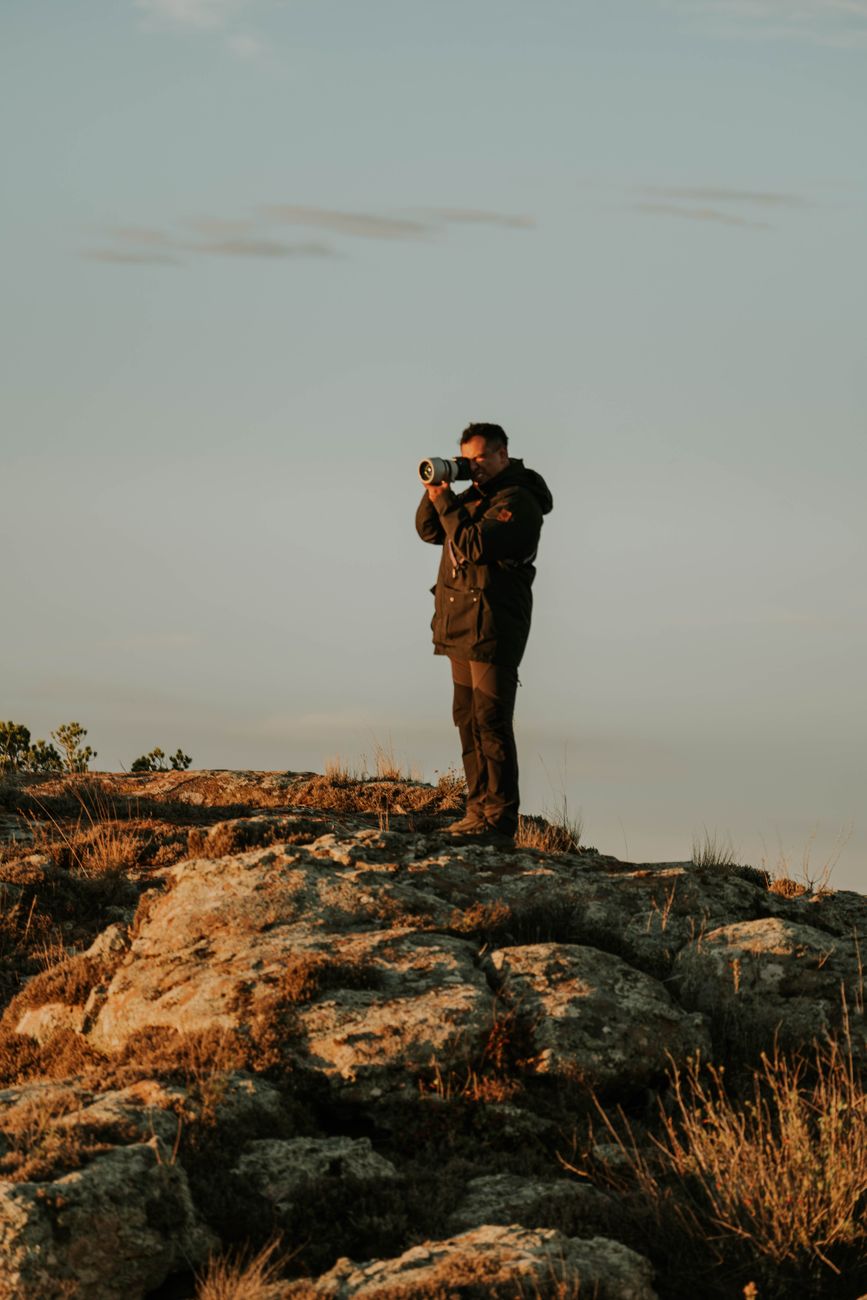 Travel photographer observing mountain valleys at golden hour